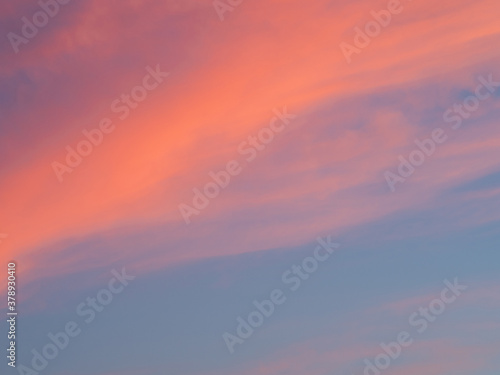 Bright sky illuminated by pink sunset light as background and texture.