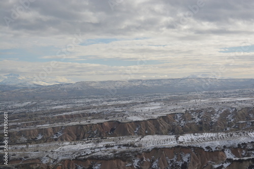 View from the top of settlements in Cappadocia. Misty view of the snowy hills of Cappadocia, Turkey. © Alp Guvenc