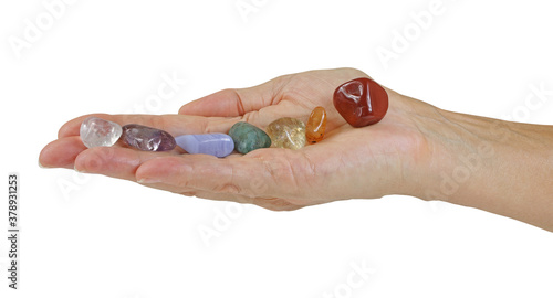 Fotografie Holding Seven Chakra Healing Stones - open flat female hand with seven tumbled c