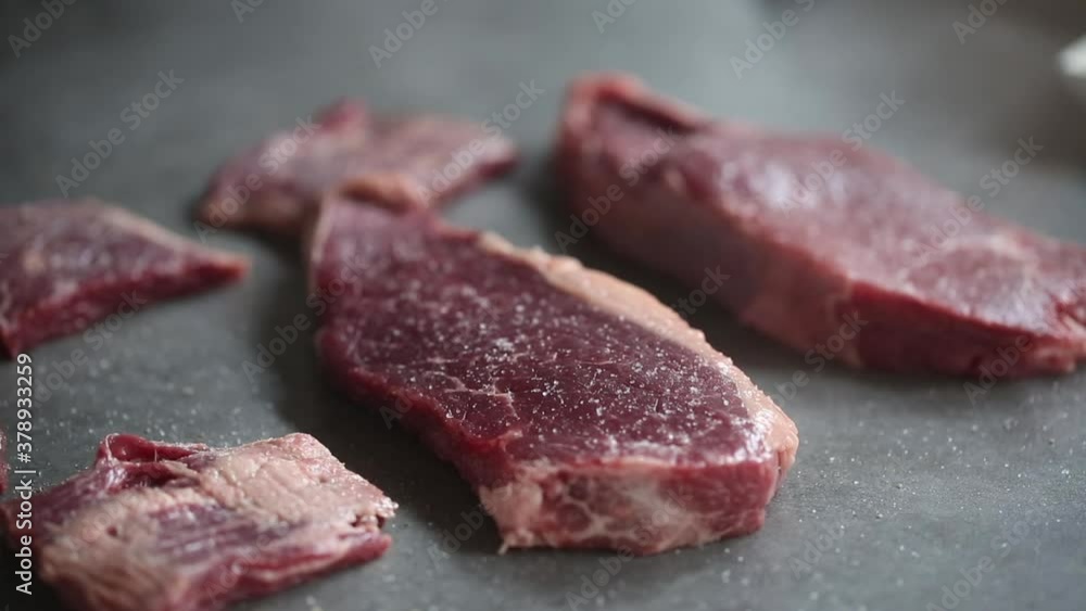 Сhef sprinkles the meat on top with salt and pepper