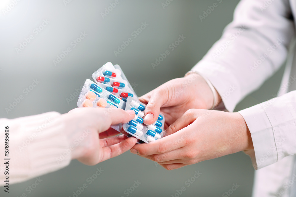 Close up of a girl hands buying pills  in a pharmacy.