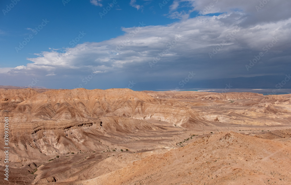 Panoramic landscape of the remote part of the Judean Desert, Israel. Hills, natural terraces with escarpments and dry wadies of the Judean Desert. Dead sea on the background. Panoramic landscape of the remote part of the Judean Desert, Israel. Hills, natural terraces with escarpments and dry wadies of the Judean Desert. Dead sea on the background.