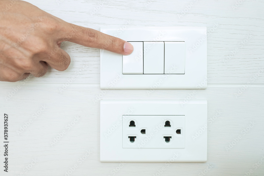 Closeup Male finger is turn on or off on light switch on white wall at home. Energy Saving, power, electrical and lifestyle concepts Closeup Male finger is turn on or off on light switch on white wall at home. Energy Saving, power, electrical and lifestyle concepts