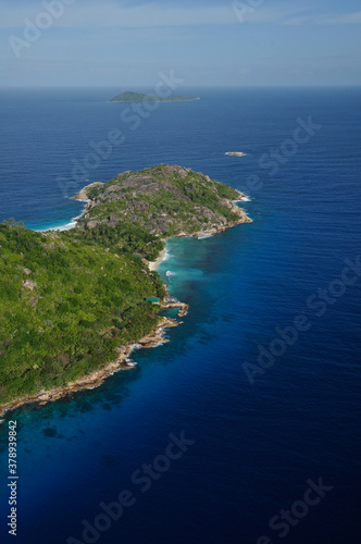 Aerial view of a tropical island with coastline and blue ocean. Félicité Island, La Digue, Seychelles