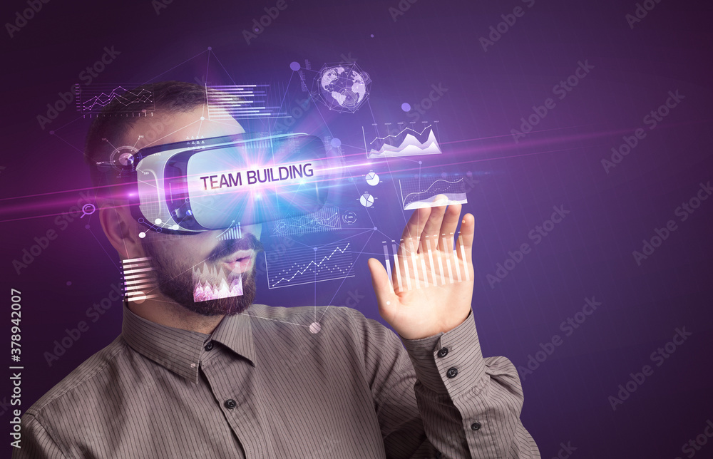 Businessman looking through Virtual Reality glasses with TEAM BUILDING inscription, new business concept Businessman looking through Virtual Reality glasses with TEAM BUILDING inscription, new business concept