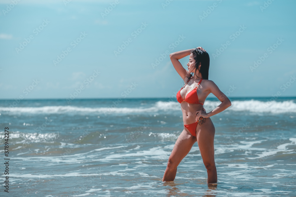 Happy woman asia enjoying beach relaxing joyful in summer by tropical blue water. Beautiful bikini orange tan skin model happy on travel wearing beach sun hat on rayong beach, Rayong, Thailand Happy woman asia enjoying beach relaxing joyful in summer by tropical blue water. Beautiful bikini orange tan skin model happy on travel wearing beach sun hat on rayong beach, Rayong, Thailand
