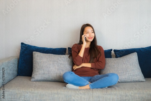 Portrait beautiful young asian woman use smart phone on sofa