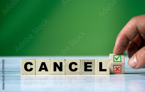 hand turns the wooden cube and changes the word CANCEL with green positive tick check box and red reject X check box.