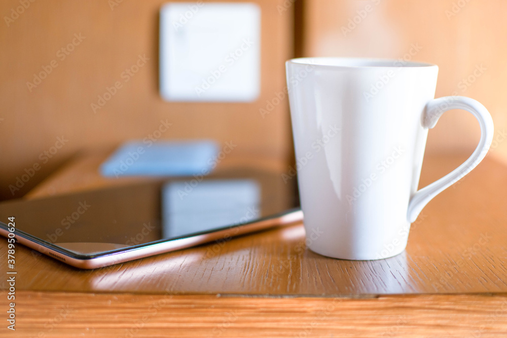 hand holding a warm drink with tablet, work from home concept hand holding a warm drink with tablet, work from home concept