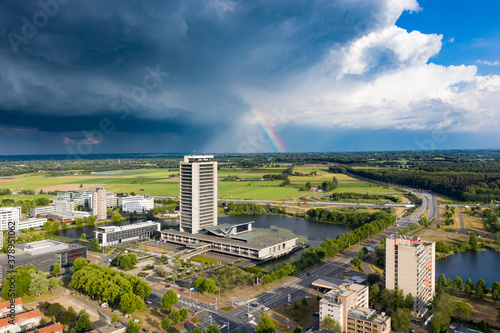 Den Bosch, 8 jun 2020 - The high rise tower skyscraper called provinciehuis with dark clouds and a rainbow in Den Bosch, Brabant, Netherlands. photo