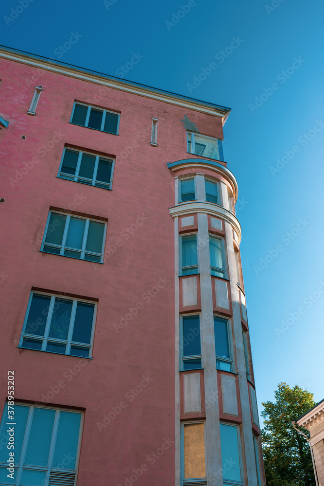 Pink building with white details and blue background