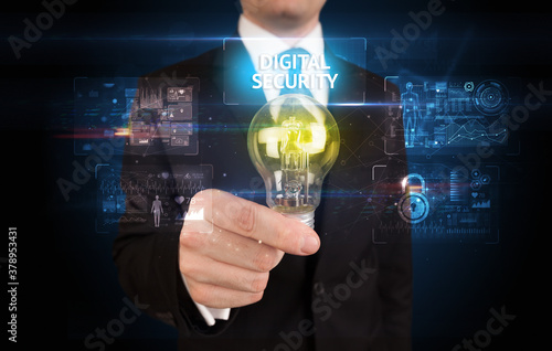 Businessman holding lightbulb with DIGITAL SECURITY inscription, online security idea concept