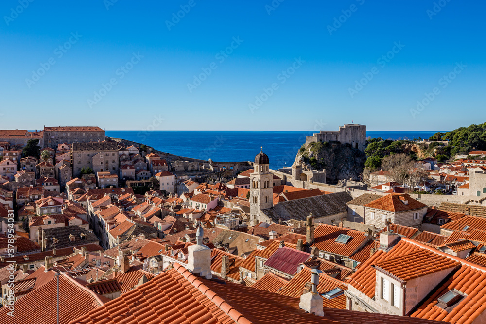 Colorful fortress street walk scene, clear sky sunny day. Beautiful building roofs. Scenery winter view of Mediterranean old city of Dubrovnik, famous European travel and historic destination, Croatia
