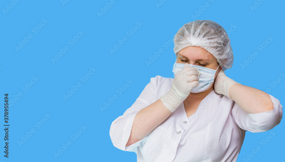 Blue-eyed nurse in overalls and personal protective equipment on a blue background. Close-up. Panorama. Place for an inscription. Blue-eyed nurse in overalls and personal protective equipment on a blue background. Close-up. Panorama. Place for an inscription.