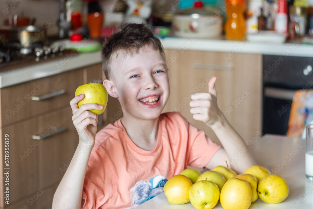 A young European boy likes the taste of an Apple. A child eats a yellow Apple. The boy gives a thumbs up. A young European boy likes the taste of an Apple. A child eats a yellow Apple. The boy gives a thumbs up.