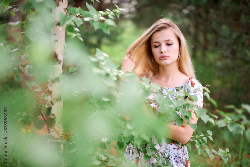 Charming girl in nature near a birch tree Charming girl in nature near a birch tree