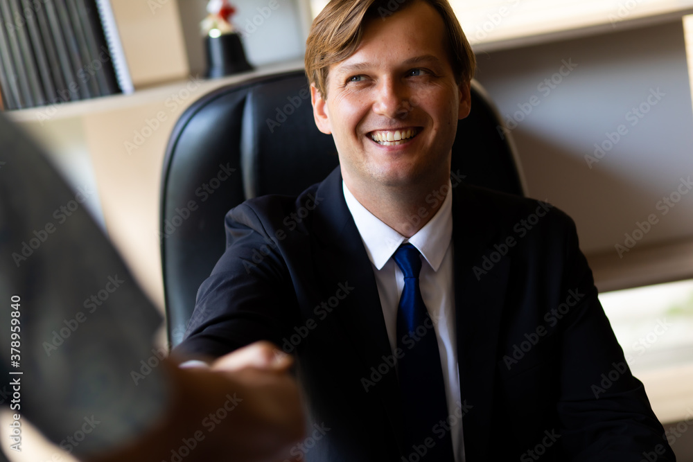 Young caucasian businessman shaking hands to deal business
