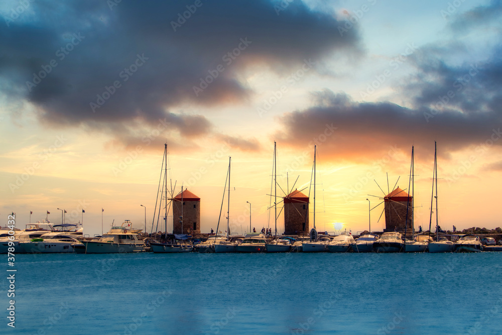 Rhodes, Greece - July 3, 2020 - The port of Rhodes with its historic windmills