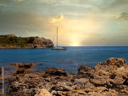 Obraz na płótnie A ship sails into a bay on the Greek island of Rhodes at sunset w salonie