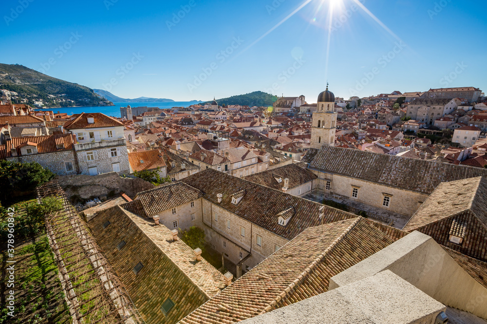 Colorful fortress street walk scene, clear sky sunny day. Beautiful high angle scene. Winter view of Mediterranean old city of Dubrovnik, famous European travel and historic destination, Croatia