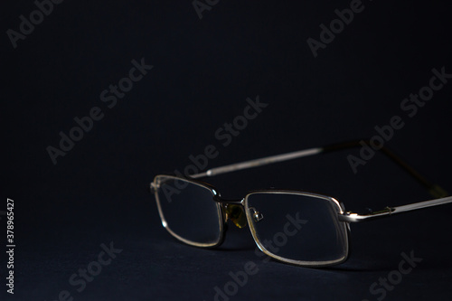 Glasses on a black background. Elegant style. There is a place for an inscription or logo.