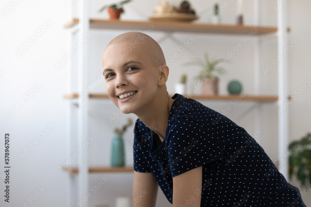 Close up portrait of smiling hairless Caucasian young female patient struggle with oncology look at camera. Happy bald sick woman suffer from breast cancer feel optimistic of recovery remission.