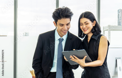 Professional asian business woman holding document file on hand and talk about business plan with business man in the workplace.