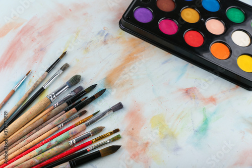 paint brushes and paints are on the table, top view