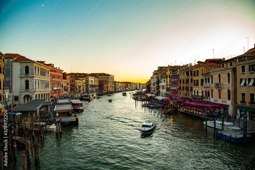 Atardecer sobre el gran canal de Venecia con lancha navegando