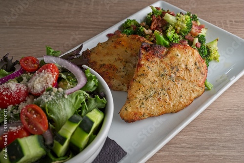 Crisp fried chicken breast piccata and mixed green salad with cucumbers, red onion, and tomatoes.