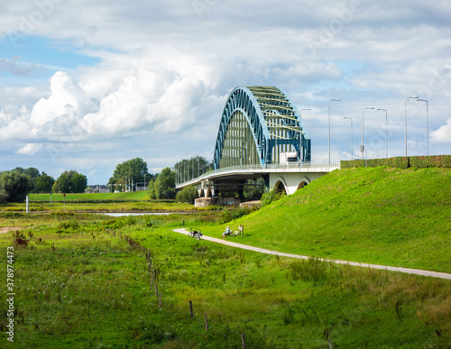 Scenery with bridge and resting cyclists near Zwolle, Netherlands
