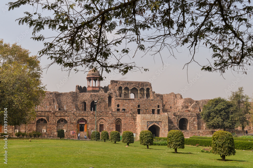 A mesmerizing view of architecture of small tomb at old fort from side lawn with trees.