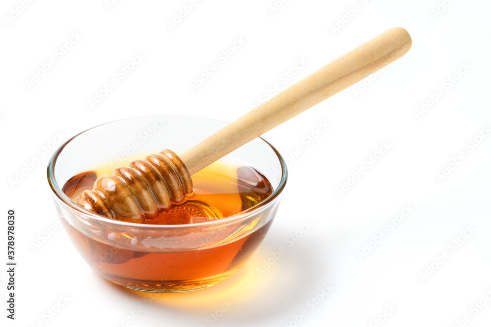 Honey with wooden honey dipper in bowl isolated on white Honey with wooden honey dipper in bowl isolated on white