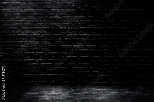 Studio dark room with black brick wall with concrete floor and lighting effect.