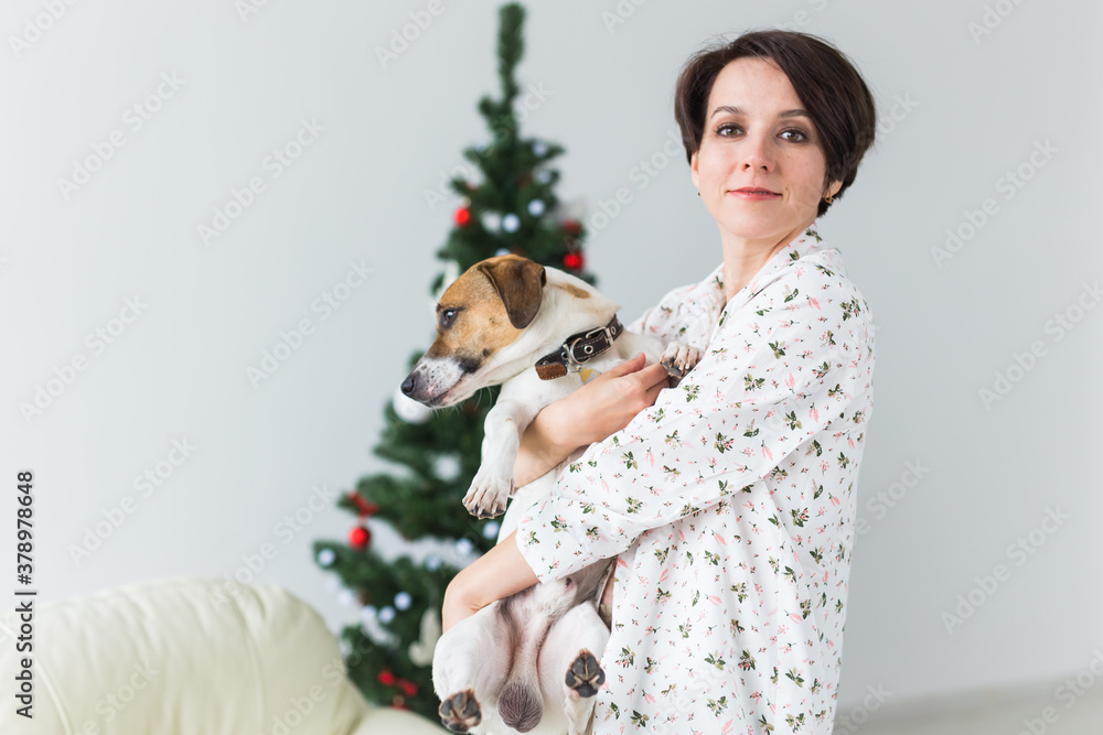 Happy young woman with lovely dog in living room with christmas tree. Holidays concept. Happy young woman with lovely dog in living room with christmas tree. Holidays concept.