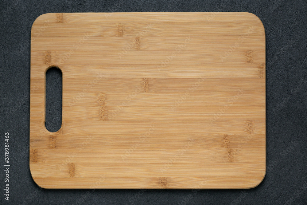 Rustic wooden cutting board on dark table top view copy space Rustic wooden cutting board on dark table top view copy space