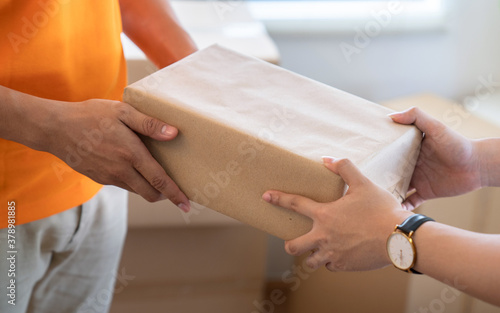 Young man receives a package from the courier's hand.