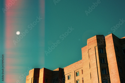 minimalistic background with moon, clear blue sky and building