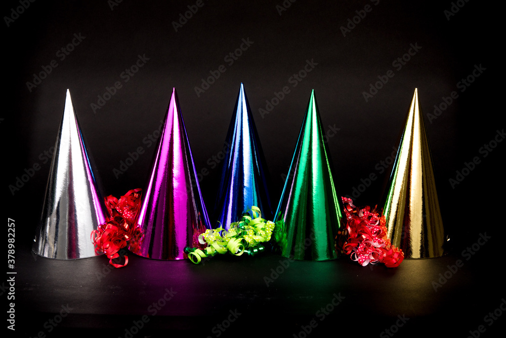 colorful new years hats and Happy New Year isolated on a black background colorful new years hats and Happy New Year isolated on a black background