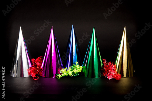 colorful new years hats and Happy New Year isolated on a black background © SockaGPhoto