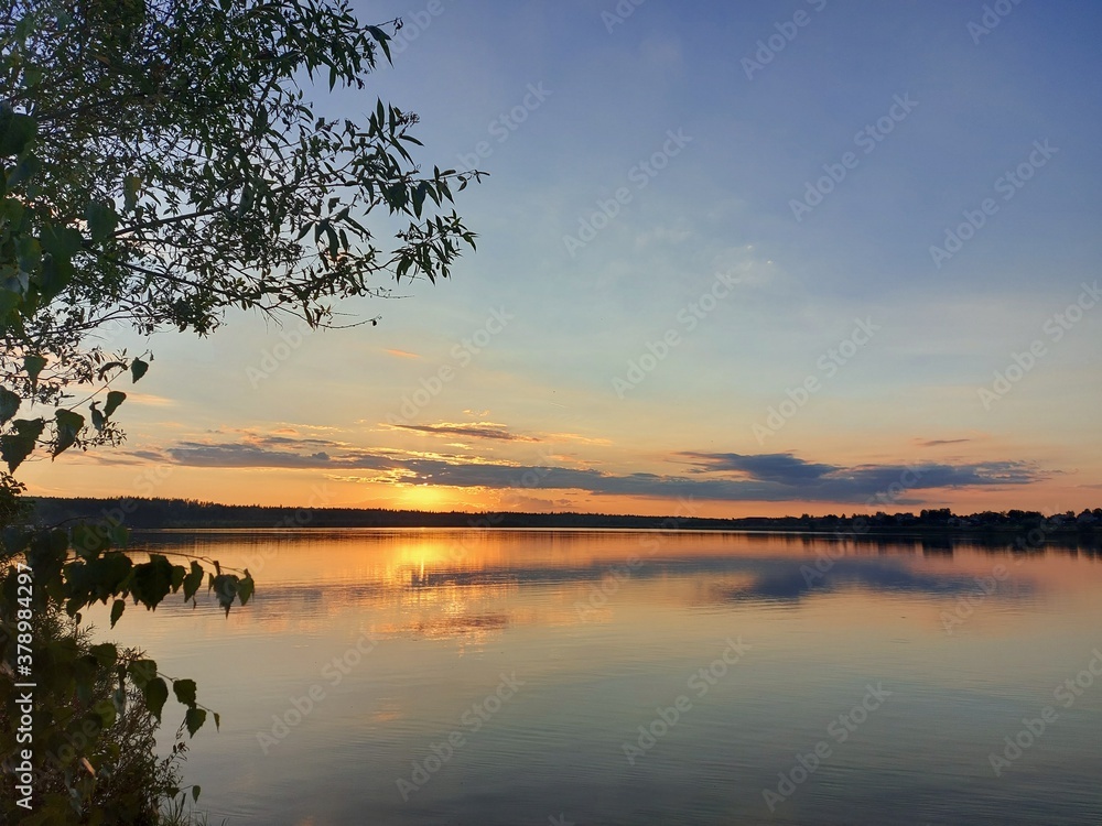 Orange sunset over a large lake in the Moscow region. High quality photo
