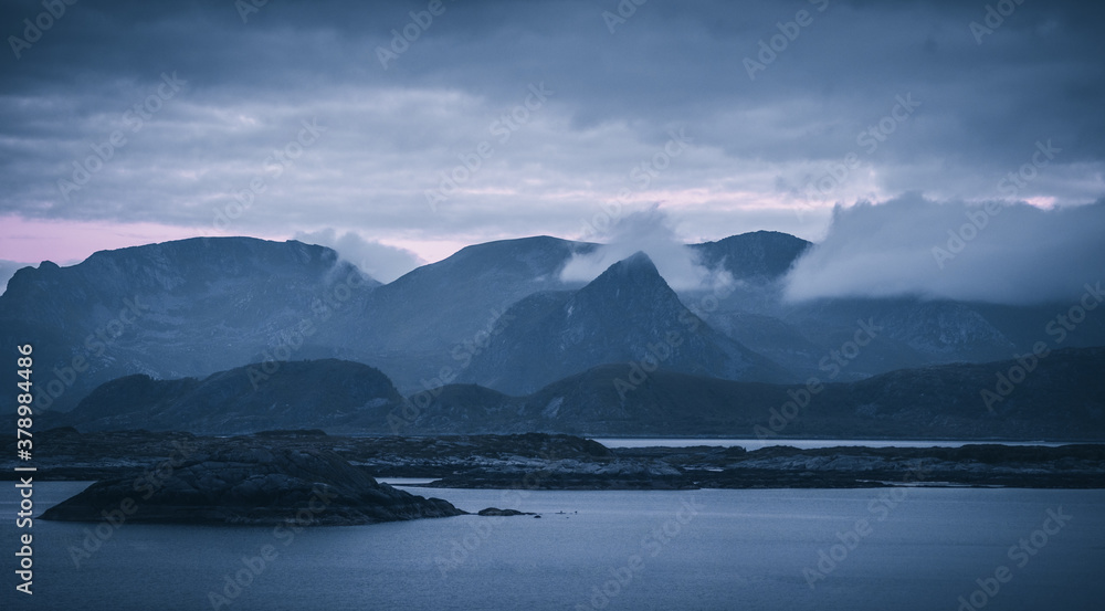 sea and mountains with fog in the blue hour