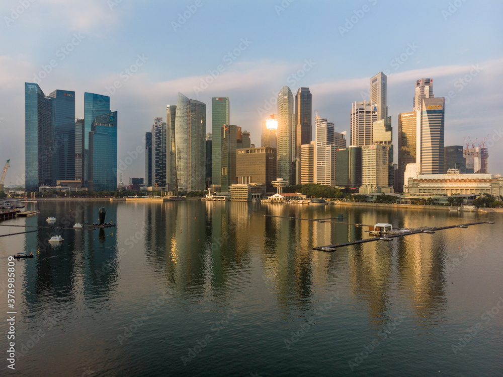 El skyline del distrito financiero de Singapur al amanecer y reflejado sobre Marina Bay