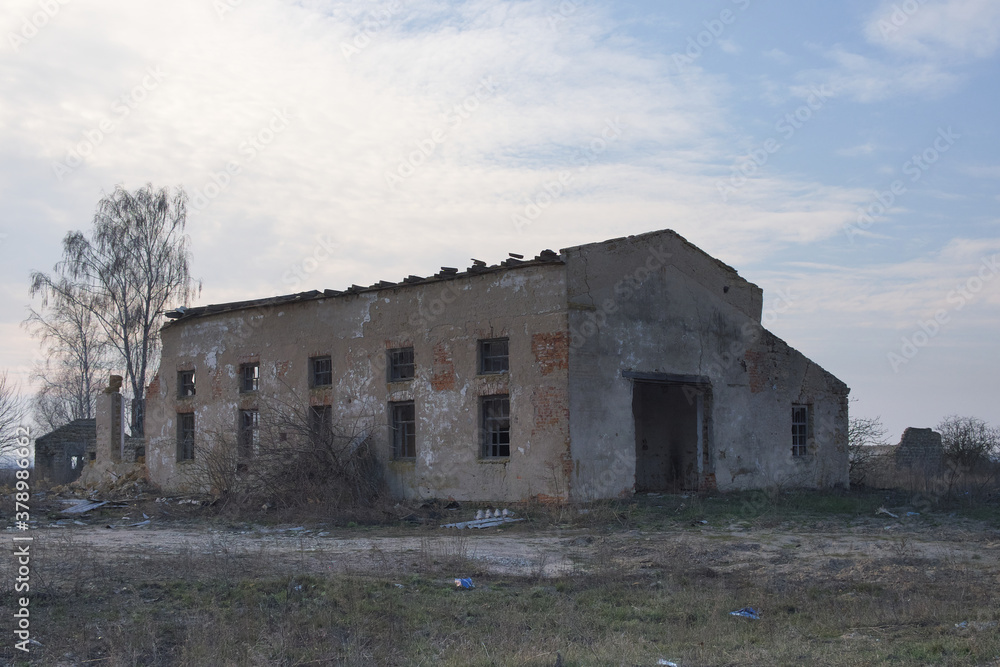 An abandoned industrial building at a farm enterprise in Ukraine. Evening landscape.