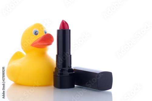 red lipstick with toy on white background