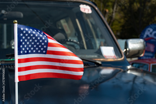 American flag waving on the car on the 4th of July, thanksgiving day  or during United States Presidential election 2020, Trump vs Biden with car on background  © Michele Ursi