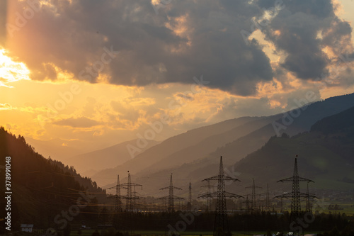 Sunset in the austrian alps with power stations infront