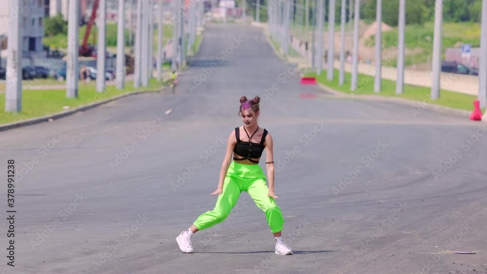 Young energetic woman dancing hip hop on wide city road. Slow motion Young energetic woman dancing hip hop on wide city road. Slow motion