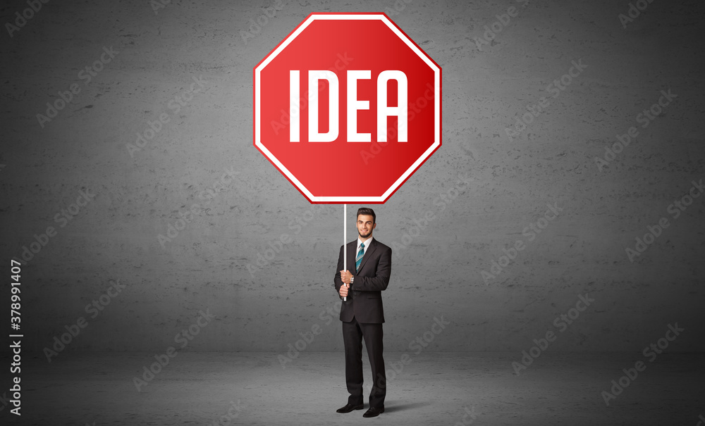 Young business person holding road sign with IDEA inscription, new rules concept Young business person holding road sign with IDEA inscription, new rules concept
