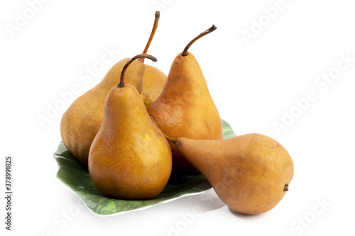 a group of golden brown Bosc pears on a plate isolated on white